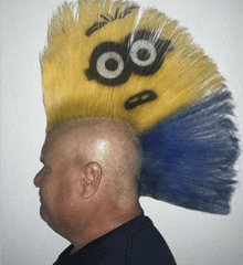 a man with a mohawk has a yellow and blue minion on his head