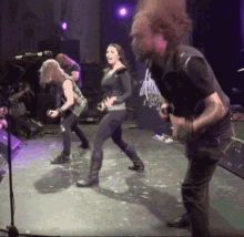 a man and a woman are dancing on a stage in front of a sign that says ' heavy metal ' on it