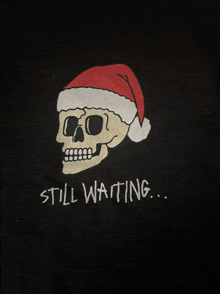 a black shirt with a skull wearing a santa hat and the words still waiting below it