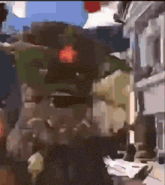 a blurry picture of a person walking down a street with a red light behind them .