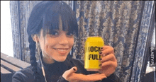 a woman is holding a yellow can that says mock full on it