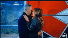 a man and a woman are kissing on a tv screen with abc written on the bottom