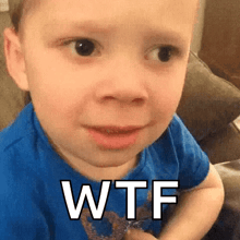a baby in a blue shirt is making a funny face with the words wtf written on his face .