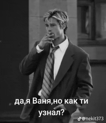 a man in a suit and tie is smoking a cigarette in a black and white photo .
