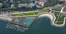 an aerial view of a beach with a dock and boats in the water