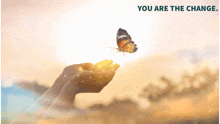 a butterfly is flying out of a person 's hands with the words " you are the change " above it