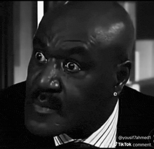 a black and white photo of a man with a surprised look on his face