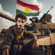 a man leaning on a tank with a kurdish flag behind him