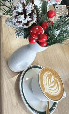 a cup of coffee on a saucer next to a vase of flowers