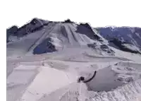 a person is riding a snowboard down a snow covered slope .