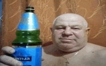 a shirtless bald man is holding a bottle of mutual