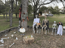 a group of skeletons sitting under a tree with a welcome sign