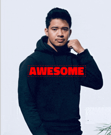 a man wearing a black hoodie that says awesome in red