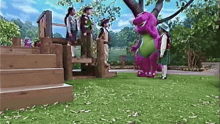 a group of children standing next to a purple and green stuffed animal called barney