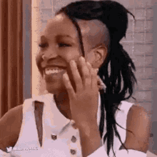 a woman with dreadlocks and a shaved head is smiling .