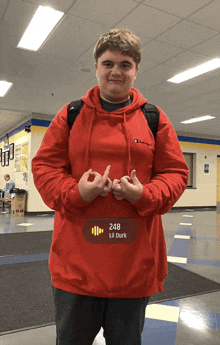 a boy wearing a red hoodie with the number 248 on the front