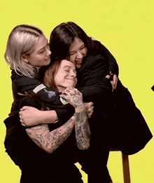 three women are hugging each other and one has a patch on her arm that says nasa