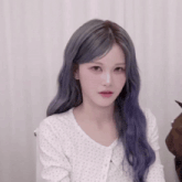 a woman with purple hair is wearing a white polka dot shirt