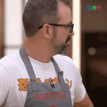 a man wearing glasses and an apron that says agustin