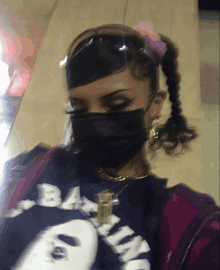 a woman wearing a mask and a shirt that says bape