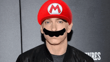 a man wearing a mario hat with a m on it