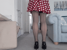 a woman in a red and white polka dot skirt and black fishnet stockings