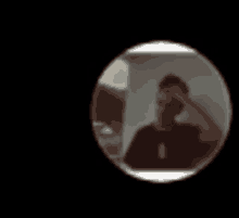 a blurry picture of a man in a black shirt is in a circle on a black background