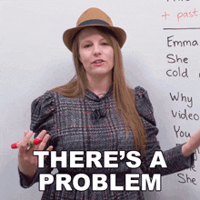 a woman wearing a hat stands in front of a white board with the words there 's a problem written on it