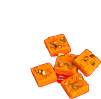 a bunch of orange squares with nuts on top of them