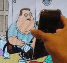 a person is holding a cell phone in front of a cartoon of peter griffin .