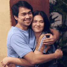 a man and a woman hugging each other and smiling