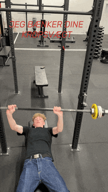 a man is lifting a barbell in a gym with the words jeg benker dine kropsvejt written on the wall