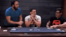 a group of men are sitting at a table with a sign that says do