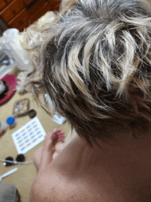 a close up of a person 's hair with a bunch of papers on the floor