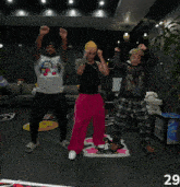 a group of men are dancing in a living room with the number 29 on the bottom