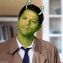 a man in a trench coat and tie with a green face