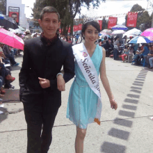 a woman wearing a sash that says senorita stands next to a man in a suit