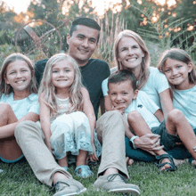 a family is posing for a picture in the grass