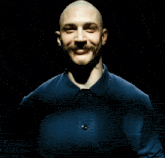 a bald man with a mustache is laughing with his mouth open