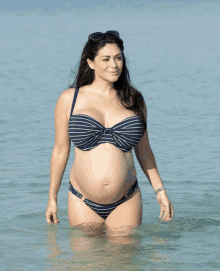 a pregnant woman in a blue and white striped bikini