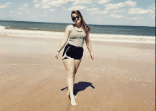 a woman is walking barefoot on a beach