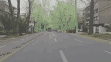 a blue bus is driving down a street with a green sign in the background