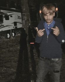 a man giving the middle finger in front of a camper trailer