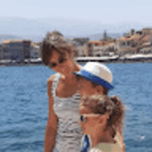 a woman and two children are standing next to each other on a boat in the water .