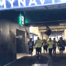 a group of people running in a tunnel under a sign that says mynavi