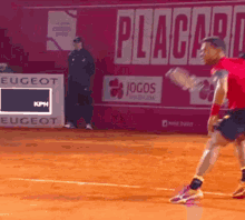 a man in a red shirt is playing tennis on a court with a sign that says eugeot in the background