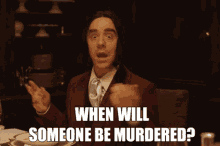 a man in a suit and tie is asking when someone will be murdered