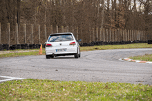 a white car with a license plate that says bp-399-tnj is driving on a track