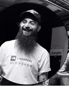 a man with a beard wears a liverpool t-shirt