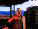 a man in overalls drinking from a bottle with the name dr pflaumisan on the bottom